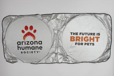 Silver car window sun shade with Arizona Humane Society logo on left panel, 